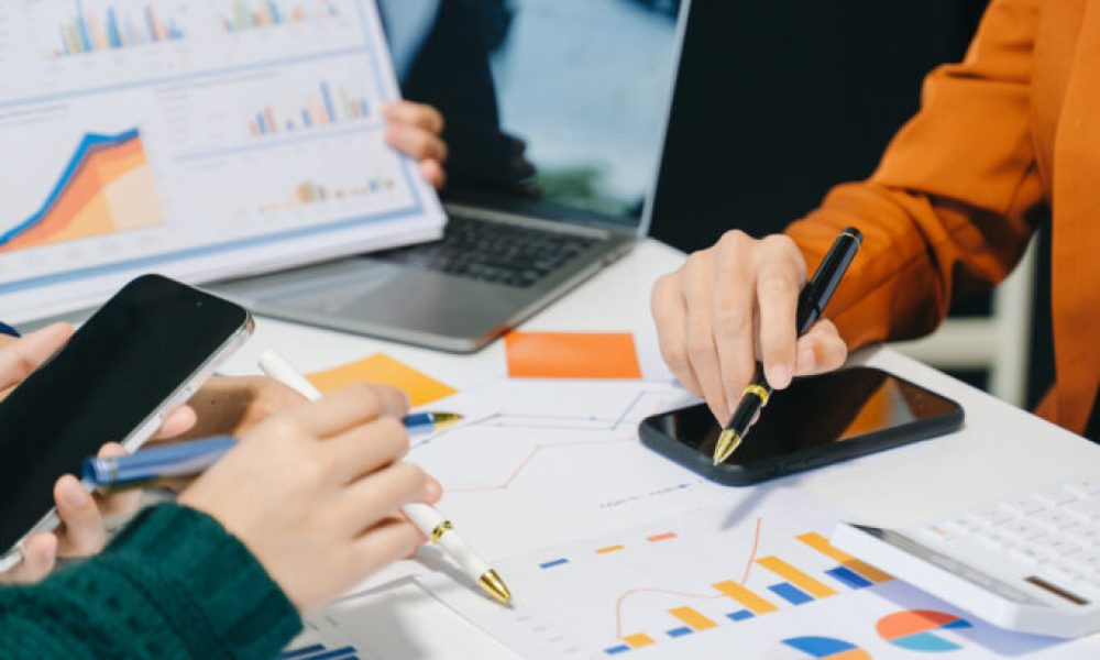 Team business meeting presentation. Hand businessman working project in modern office.Laptop computer and tablet and smart phone on white desk in morning light